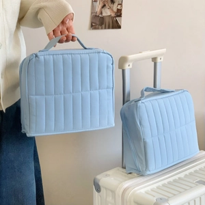 Vertical blue quilted travel cosmetic bag set with top handle and secure zipper closure