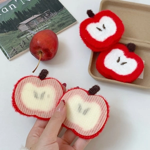 Detail of red apple plush hair clip with embroidery texture and white core decoration