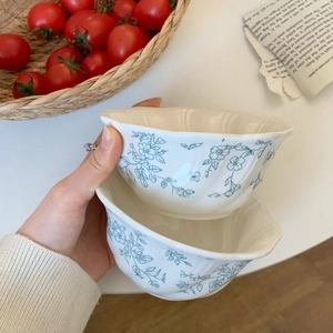 Detail of French vintage ceramic bowl with embossed floral pattern and wavy scalloped edge