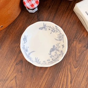 Detailed macro view of cream ceramic bowl with blue magpie and floral patterns
