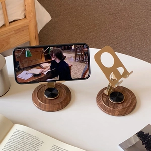 Detail of vintage wood grain phone stand with adjustable gold metal arm on white desk