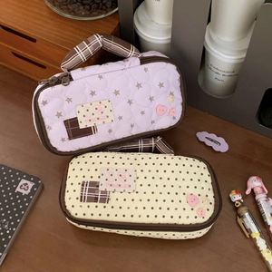 Quilted cotton pencil cases with star and dot patterns showing portable side handles