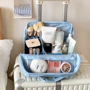 Macro view of light blue travel makeup bag interior with compartments and mesh slots