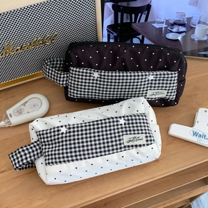 Détail de trousses en toile à pois avec paillettes étoiles et étiquette tissée sur table
