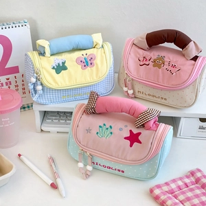 Detail of high-capacity quilted pencil cases with colorful patterns and embroidery