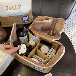 Detail view of large brown suede makeup bag with JOLLY embroidery and inner compartments