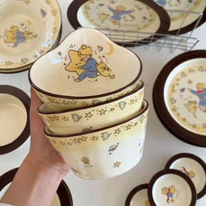 Ceramic tableware set with Little Prince theme featuring bowls and plates in warm beige finish