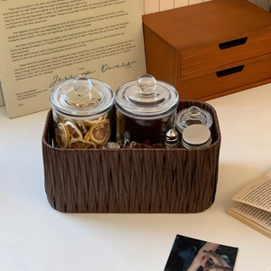 Detailed view of a vintage woven storage basket with four elegant glass organizer jars