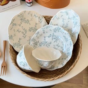Close-up of French vintage ceramic plates with blue floral relief in a woven basket