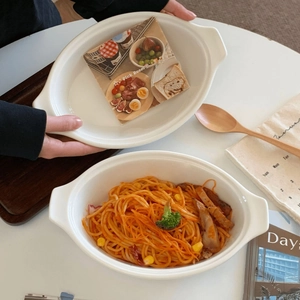 Close-up of white ceramic oval pasta plate with side handles in a cozy home setting
