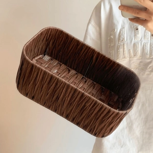 Detail of dark brown rectangular handwoven storage basket with textured paper rope pattern