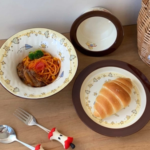 Detail of ceramic noodle bowl set with star pattern and cute apple-shaped spoon handle