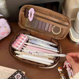 Detail showing high-capacity double-layer pencil case with brown polka dot and mesh pocket
