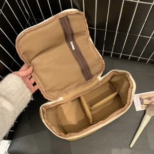 Interior detail of large suede vanity case showing mesh pocket and spacious compartments