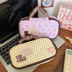 Quilted storage bag detail showing star and polka dot patterns on a desk workspace