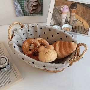 Close-up of a hand-woven basket with polka dot lining filled with assorted bread and bagels