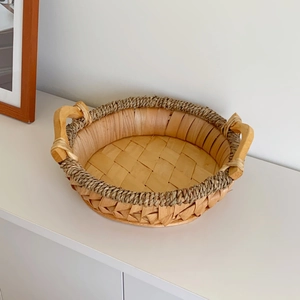 Detail of hand-woven storage basket with sturdy wooden handles and natural wood texture