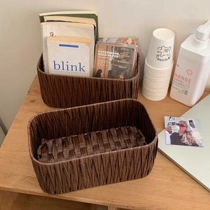 Detail of dark brown woven storage baskets for desk organization in an office setting