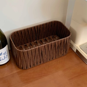 Close-up of deep brown woven storage basket texture on a warm wooden tabletop surface