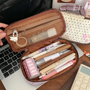 Detail of multi-layer purple stationery pouch showing large capacity interior with dot lining
