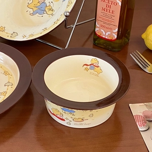 Detail of ceramic Little Prince noodle bowl and plate set with vintage brown rim on wood