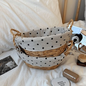 Detail of woven rattan storage baskets with polka dot liners and twin handles