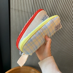Detail view of plaid and solid pencil cases with convenient hand straps and sturdy zippers