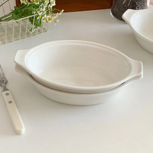 Oval white ceramic baking dish with double handles and glossy finish for salads