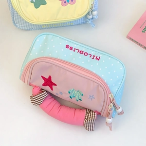 Detail of macaron blue polka dot pencil case with pink handle and starfish embroidery