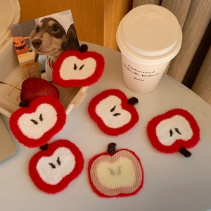 Detail of red apple fringe hair patch showing felt texture and magic sticker backing