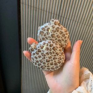 Detailed close-up of leopard print folding hairbrush with integrated vanity mirror