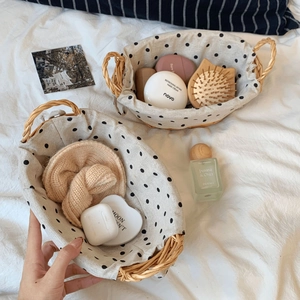 Detail of woven baskets with polka dot fabric lining and dual handles for home storage