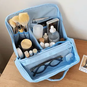 Detailed interior of a blue makeup bag with brush slots and organized compartments