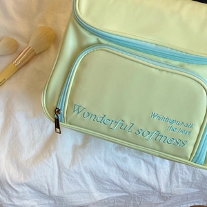 Détail de la trousse de maquillage vert menthe en cuir PU avec broderie délicate