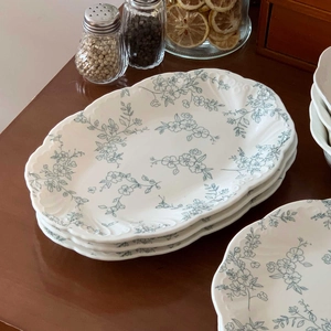 Detail of French vintage ceramic plate with blue floral pattern and wavy scalloped edges