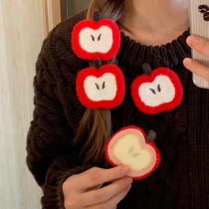 Close-up of red crochet apple hair clips with soft plush texture for girls hair styling