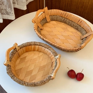 Close-up of two handcrafted woven wooden trays with handles for home organization