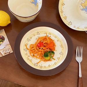 Detail of cartoon ceramic dinnerware set with star and moon patterns on a wooden table