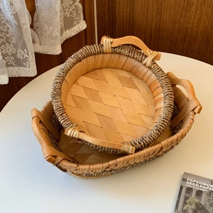 Set of two handmade woven rattan storage baskets with wooden handles in rustic style