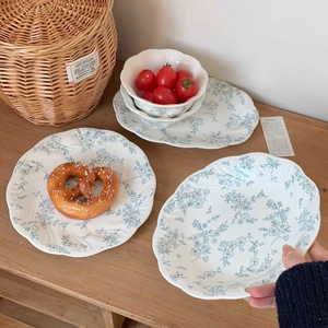 Close-up of French vintage ceramic plate set with light blue floral embossed patterns