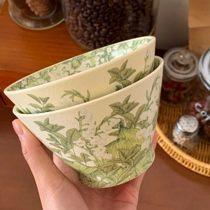 Close-up of hand holding a lily of the valley ceramic bowl with matte floral texture