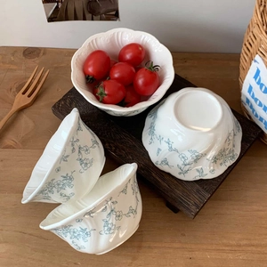 Detail of vintage French ceramic bowls with blue floral relief and wavy edge design