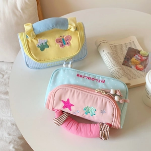 Close-up of embroidered handheld pencil cases with soft fabric handles and cute patterns