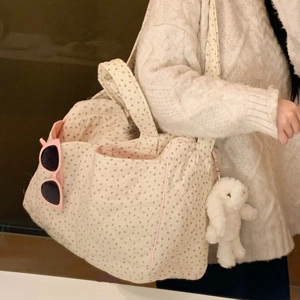 Cream quilted tote bag with floral patterns, pink trim, and cute rabbit pendant