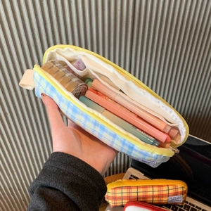 Inside view of checkered pencil case showing large capacity storage and mesh pockets