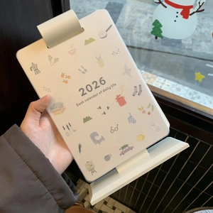 Close-up of 2026 desk calendar with minimalist hand-drawn illustrations on white paper