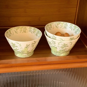 Detail of ceramic lily of the valley bowls with eggs on a rustic wooden shelf