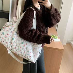 Detail showing high-capacity waterproof travel bag with cute cartoon kitty print and strap