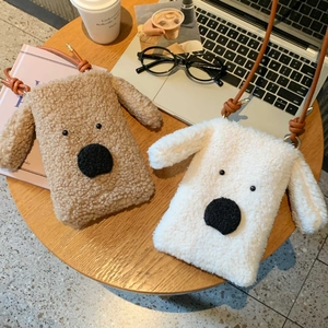 Detailansicht der flauschigen Welpen-Umhängetaschen in Beige und Braun auf einem Holztisch