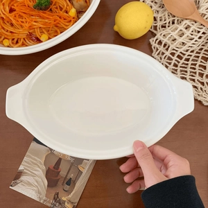 Close-up of white ceramic oval baking dish with handles for pasta or salad